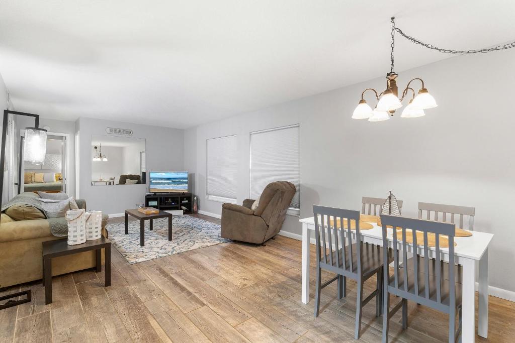 a living room with a table and a couch at Sea Coast Gardens II 115 in New Smyrna Beach