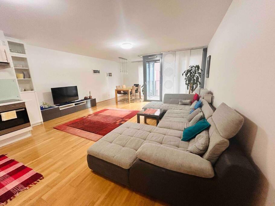 ein Wohnzimmer mit einem Sofa und einem Tisch in der Unterkunft Comfortable living in our spacious home in Wien