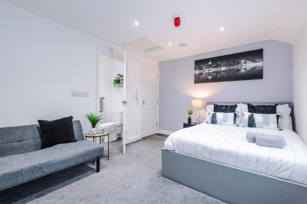 a white bedroom with a bed and a couch at Modern Studio Hindley in Hindley