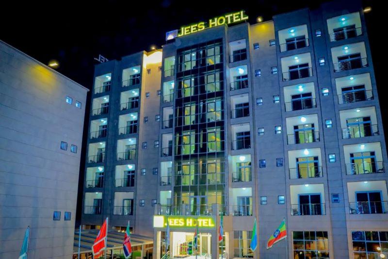 un edificio de hotel con un cartel en él por la noche en Jees Hotel, en Hargeysa