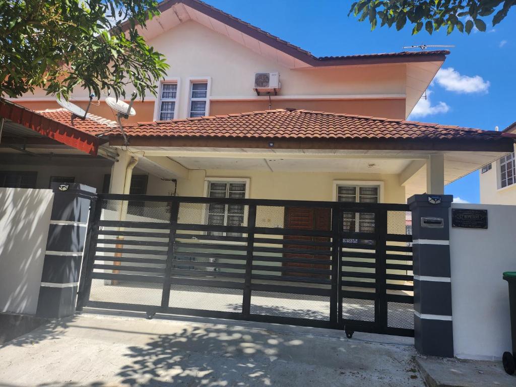 a house with a black fence in front of it at Ct HOMESTAY in Changlun