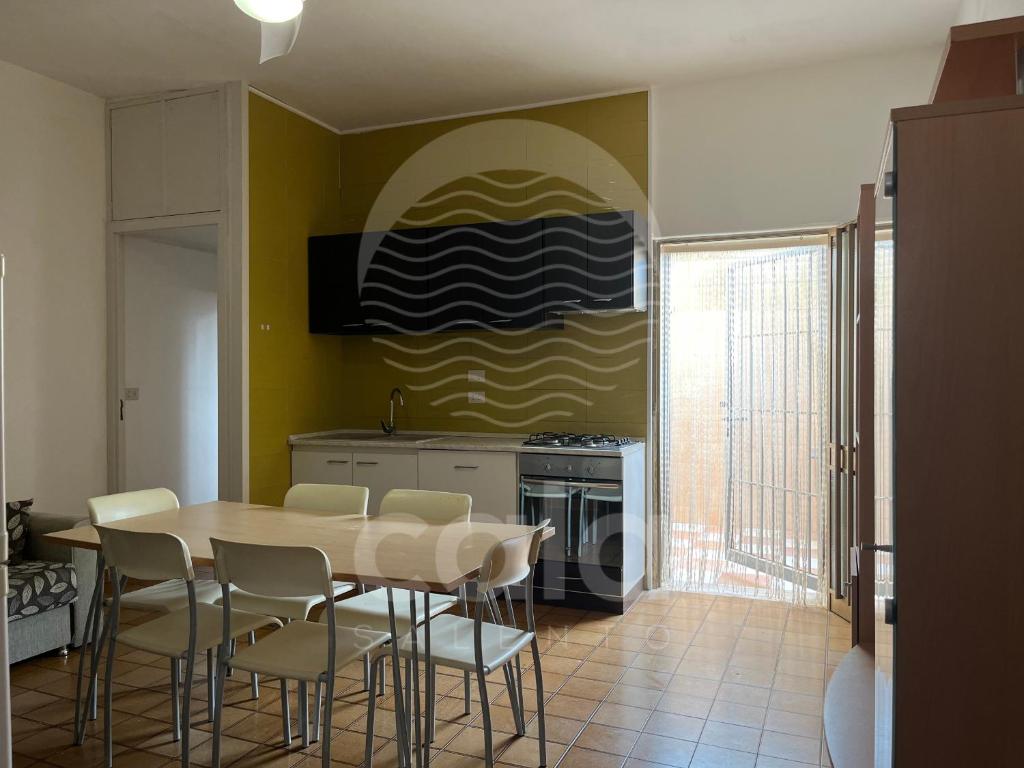 a dining room with a table and chairs in a kitchen at Villetta Zora - Spiaggia a 250m in Porto Cesareo
