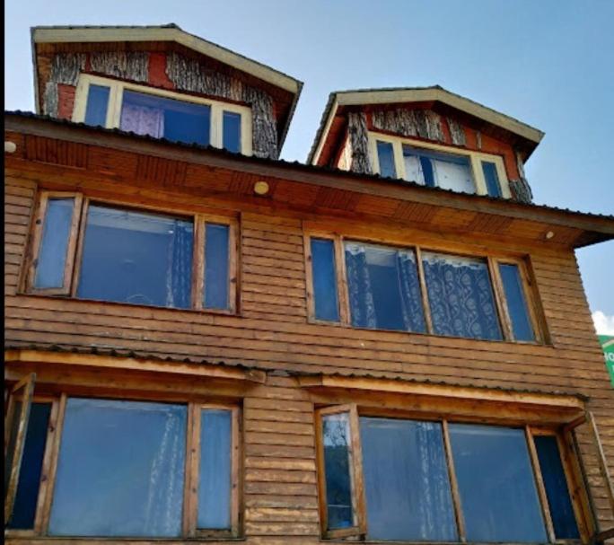 a wooden house with windows on top of it at Hotel The Holy Land in Pahalgām