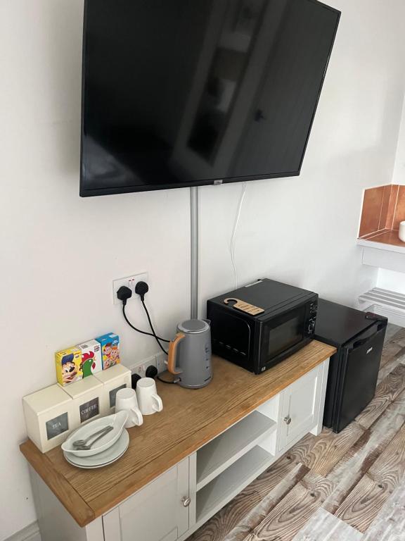 a microwave sitting on a counter with a television on it at Beech, Country Chalet In Pegsdon in Hexton