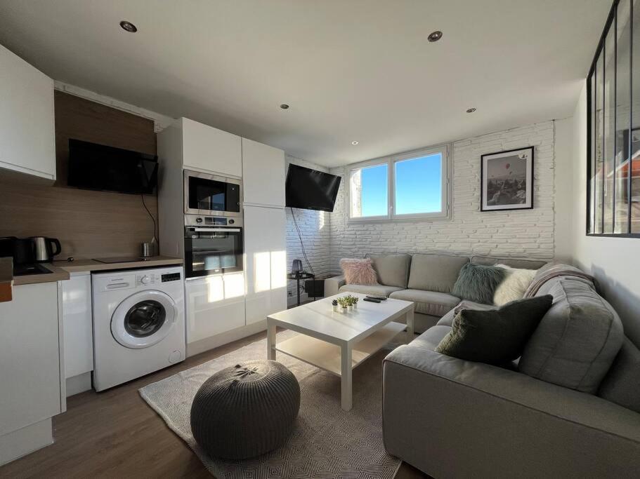 un salon avec un canapé et une table dans l'établissement Appartement Standing 3ch 3SdB, à Toulouse