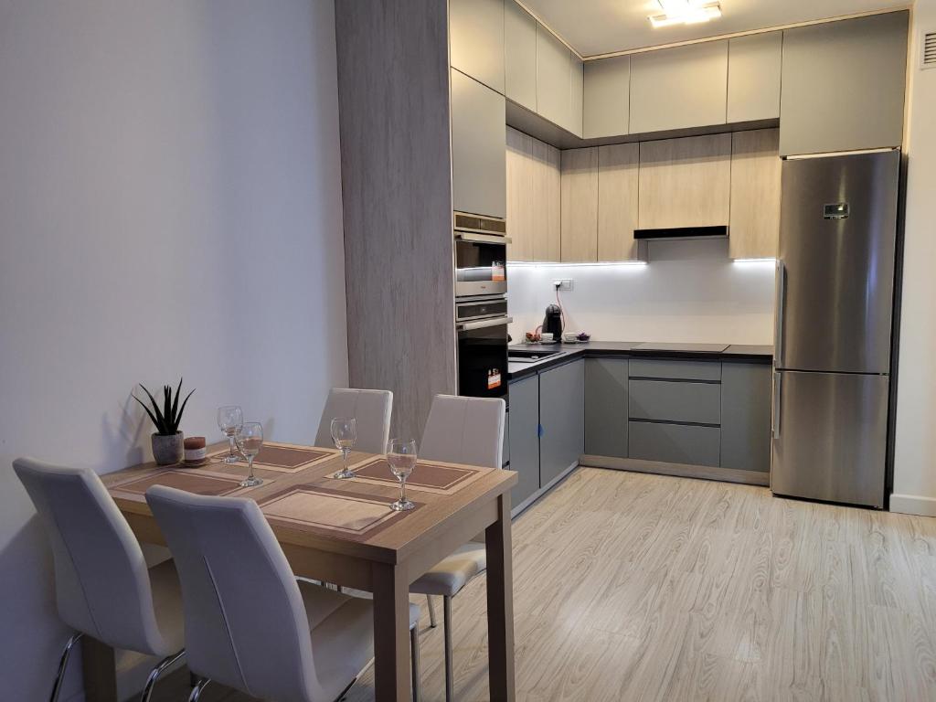 uma cozinha com uma mesa e cadeiras e um frigorífico em Cozy Appartment with Gym, free Parking, Ursus em Varsóvia