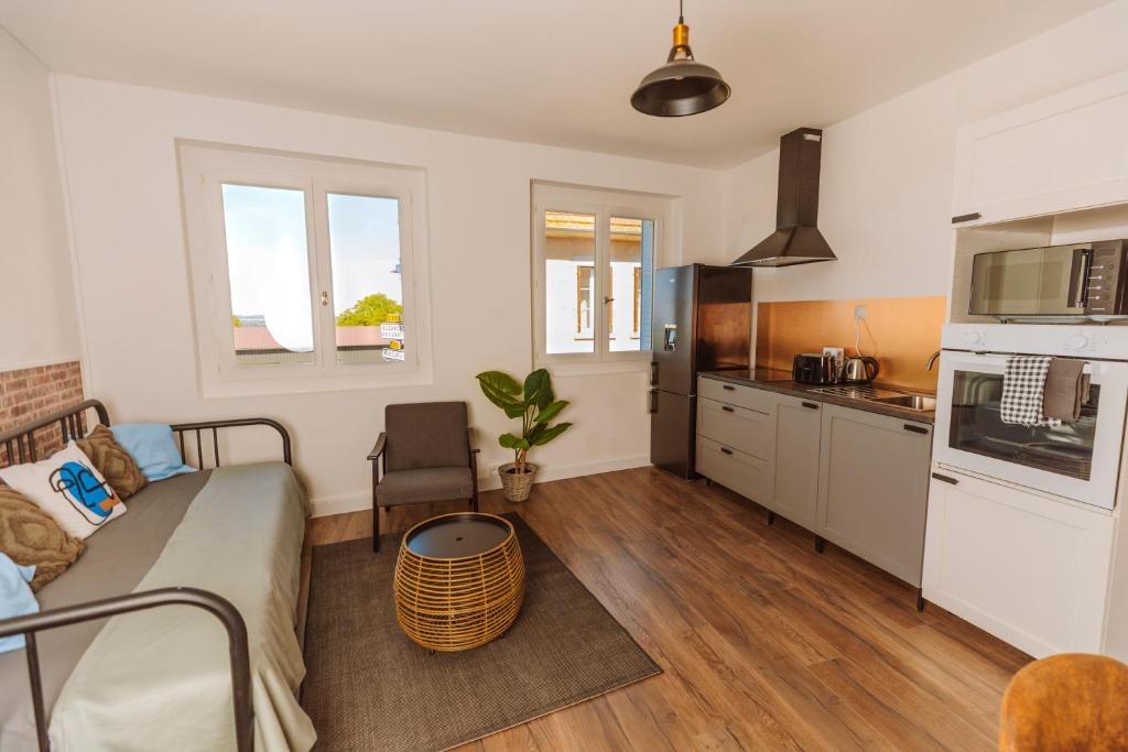 un salon avec un lit et une cuisine dans l'établissement Bel appartement 35 m 1er étage, à Évaux-les-Bains