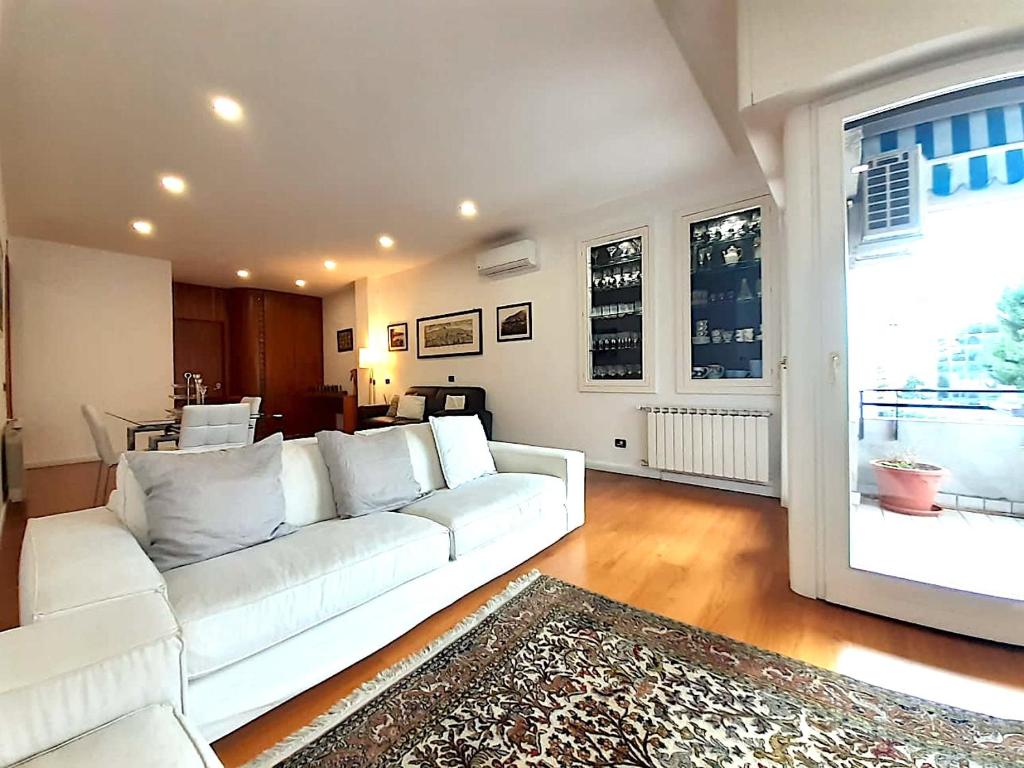 sala de estar con sofá blanco y ventana grande en YourHome in Vico, en Vico Equense