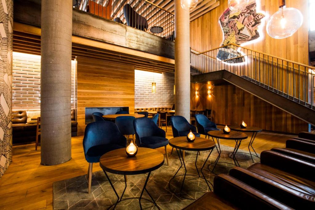 a restaurant with tables and chairs and a staircase at Canopy by Hilton Reykjavik City Centre in Reykjavík