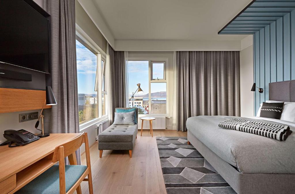 a hotel room with a bed and a chair at Canopy by Hilton Reykjavik City Centre in Reykjavík