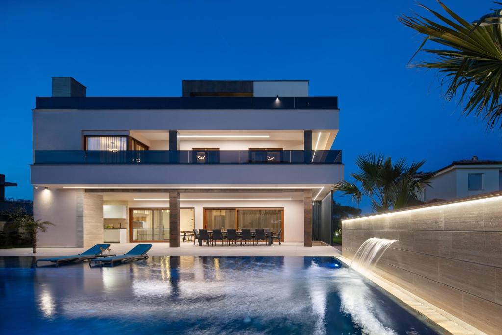 una casa con piscina por la noche en Malibu Royal, en Vir