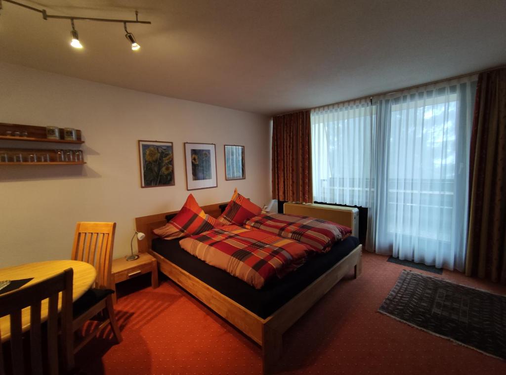 ein Schlafzimmer mit einem Bett und einem großen Fenster in der Unterkunft Ferienwohnung mit Schwimmbad und Gartenblick in Sankt Englmar