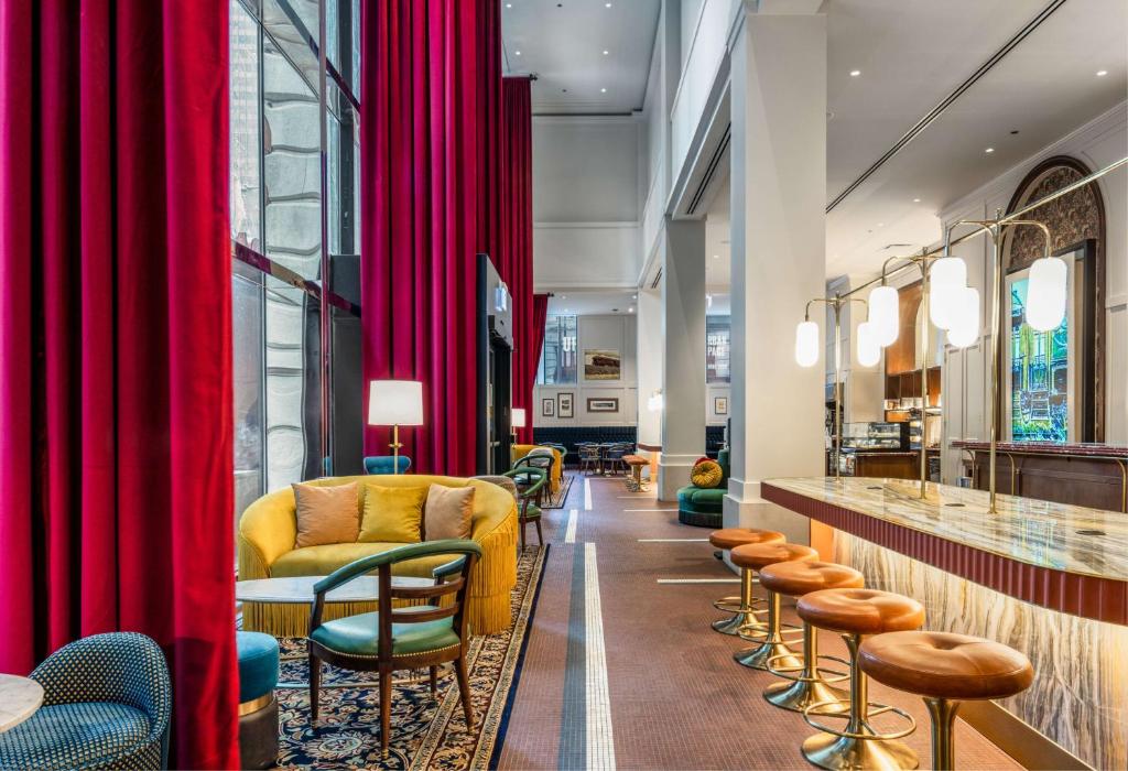 a lobby with red curtains and a yellow couch at Canopy By Hilton Chicago Central Loop in Chicago