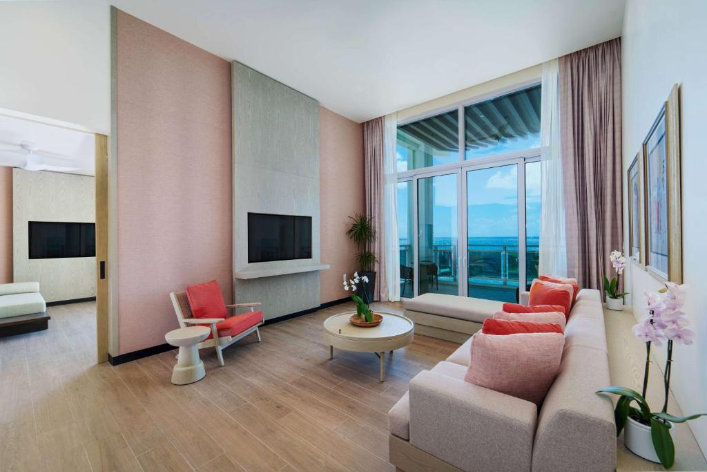 a living room with a couch and a large window at Wyndham Grand Barbados Sam Lords Castle All Inclusive Resort in Saint Philip