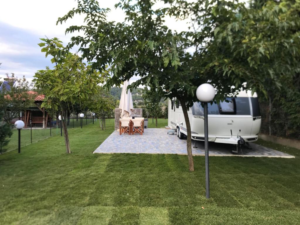 - un parking dans une cour avec une table et des chaises dans l'établissement Delightful RV Camper In a Peaceful Area near Sea., à Skála Foúrkas