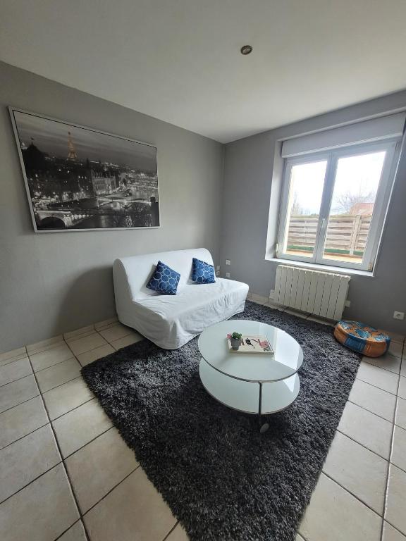 un salon avec un canapé et une table basse dans l'établissement Appartement cosy dans beau village de Champagne, à Cormicy
