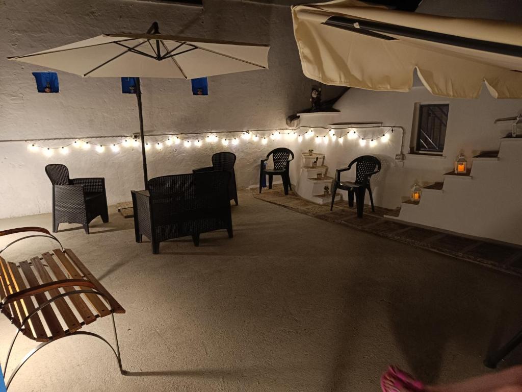 um quarto com cadeiras e um guarda-sol e luzes em U Casied em Montalbano
