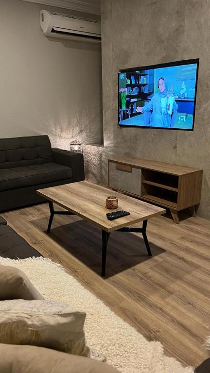 salon ze stolikiem kawowym i telewizorem z płaskim ekranem w obiekcie شقة مفروشة بحي الشراع بالخبر w mieście Al-Chubar