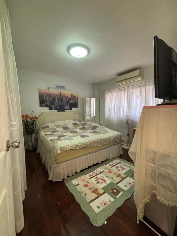 a bedroom with a bed and a television in it at Soft Power Host House in Ban Ko
