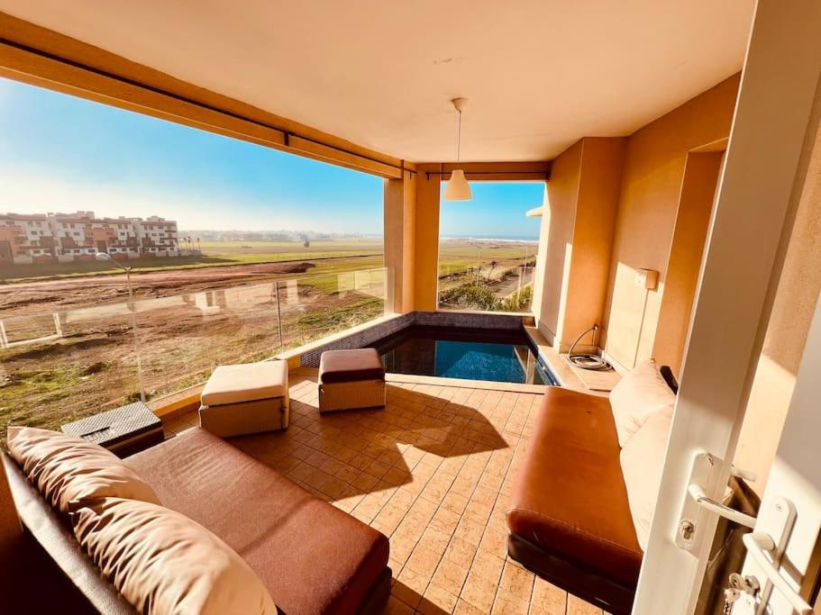 ein Wohnzimmer mit einem Sofa und einem großen Fenster in der Unterkunft Bouznika, Seaside Escape - Surf, Relaxation, Pools - at StayInMoroccoVibes in Bouznika