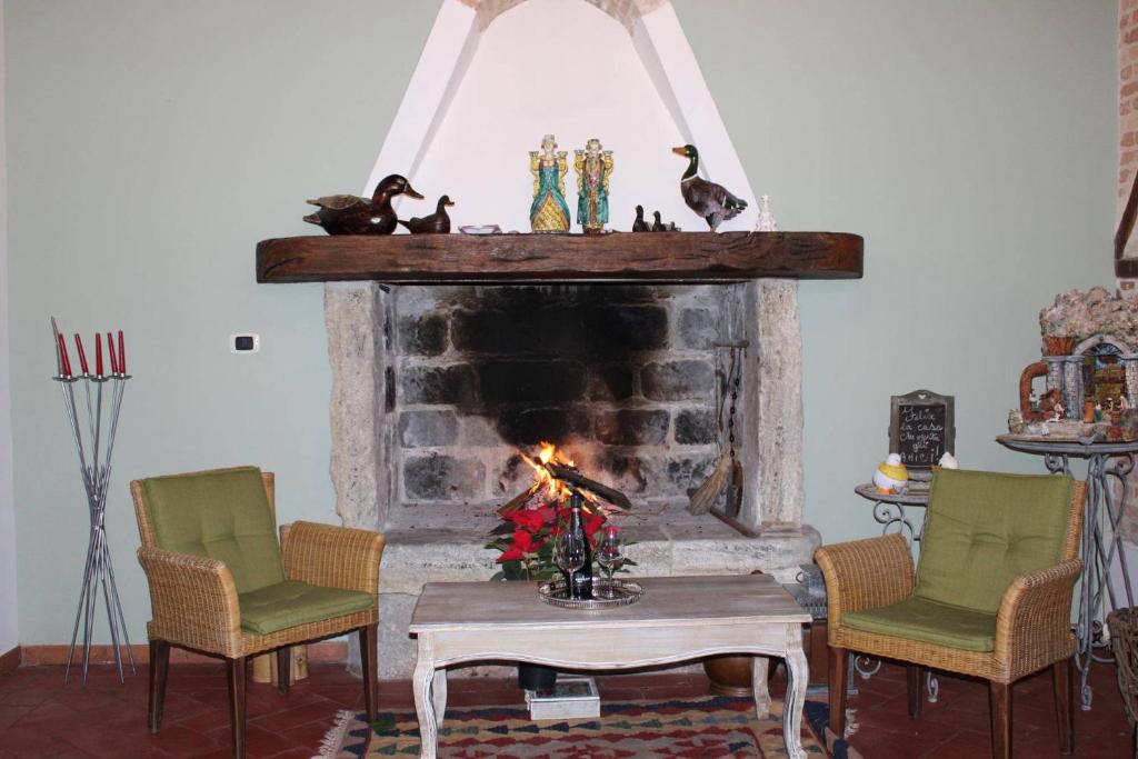 ein Wohnzimmer mit einem Kamin, Stühlen und einem Tisch in der Unterkunft Antica Cantina Emilia in Reggio di Calabria