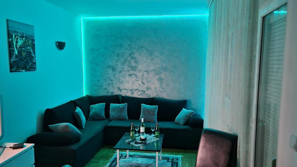 un soggiorno con divano nero e tavolo di Apartman Nikola a Žarkovo