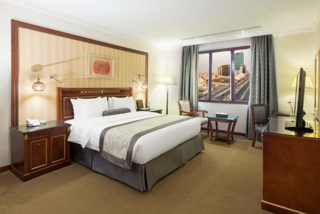 فندق كوايت الشاطئ  في جدة: غرفة فندقية بسرير كبير ونافذة