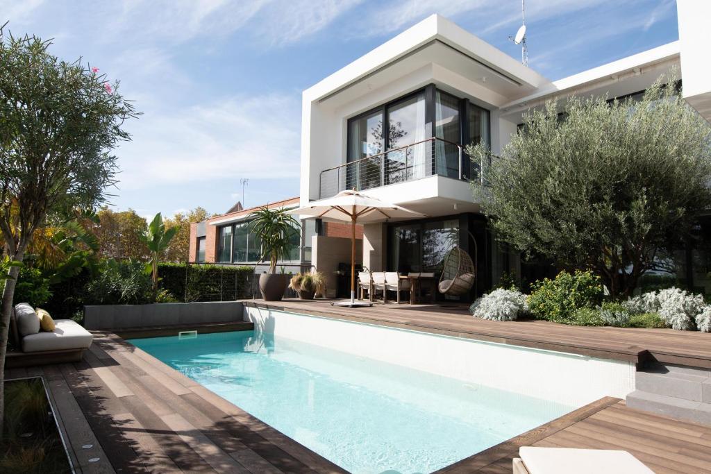 a house with a swimming pool in front of it at Villa Lujo Castelldefels Barcelona in Castelldefels