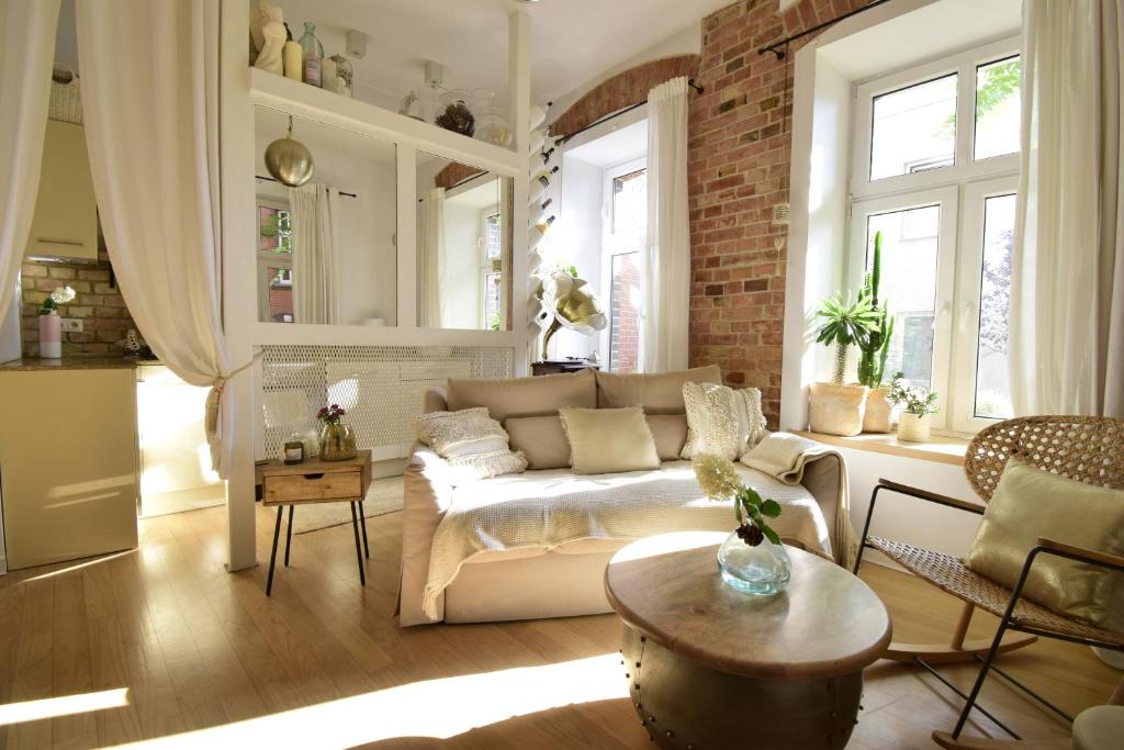 a living room with a white couch and a brick wall at Style & Center Spot in Poznań