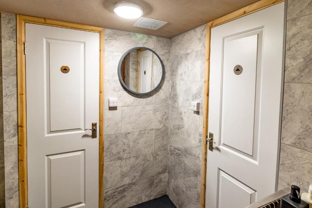 a bathroom with a white door and a mirror at Cwmcarn Hotel & Bunkhouse in Cwmcarn