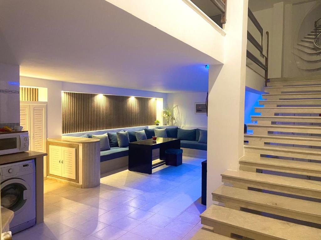 ein Wohnzimmer mit einem Sofa und einer Treppe in der Unterkunft Elegant Relaxing Oasis in the Heart of Sfax in Sfax