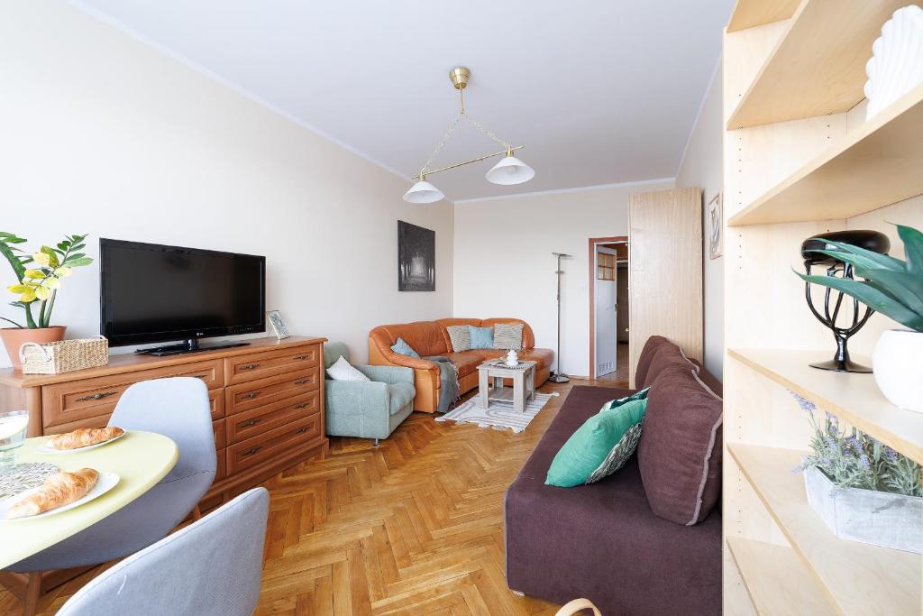 a living room with a couch and a tv at Apartament 2 pokoje w Gdańsku blisko morza 1000 m do plaży in Gdańsk