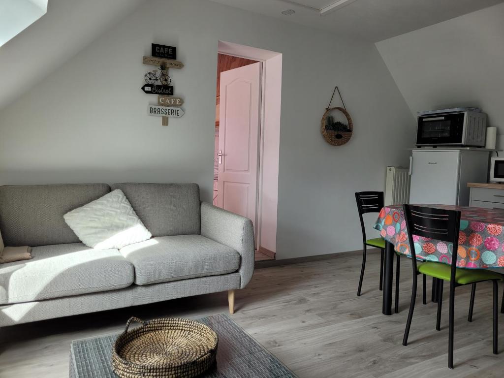 a living room with a couch and a table at Gîte Évasion idyllique à l&#39;étage près zoo-chateaux in Faverolles-sur-Cher