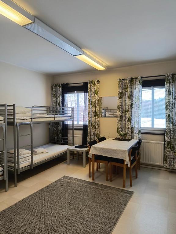 a dorm room with bunk beds and a table at Södra Bergets Vandrarhem in Sundsvall