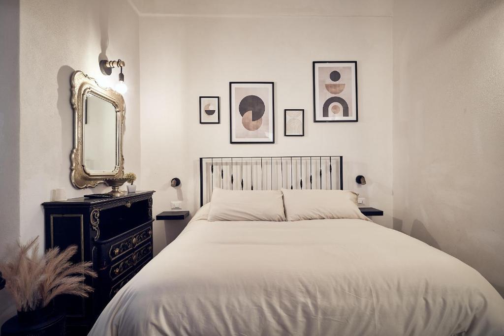 a bedroom with a bed and a mirror and a dresser at A ca' de Lisetta in Albenga