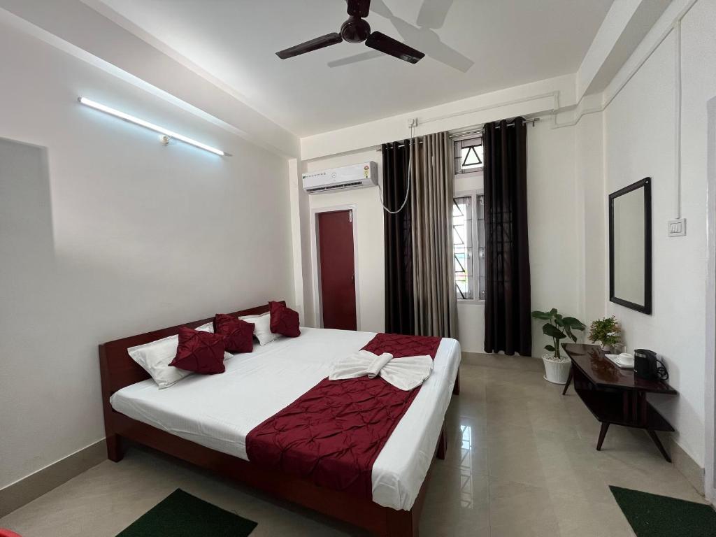 um quarto com uma cama e uma ventoinha de tecto em USC Home Stay-304 em Guwahati