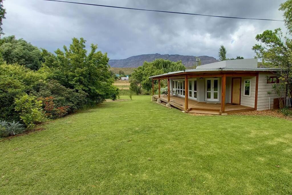 a small house in a field with a yard at River Studio in Barrydale