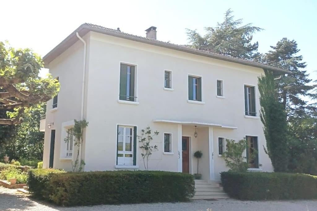 a white house with trees and bushes at Maison de maître parc privé proche Crest et Drôme. in Crest