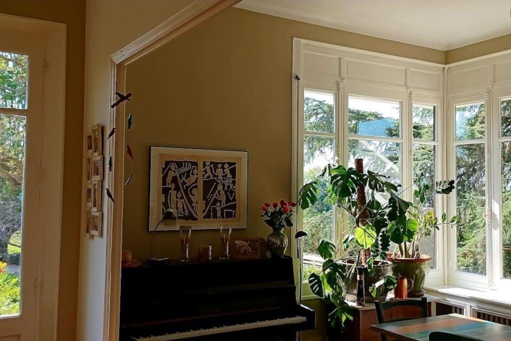 a living room with windows and a potted plant at Maison de maître parc privé proche Crest et Drôme. in Crest