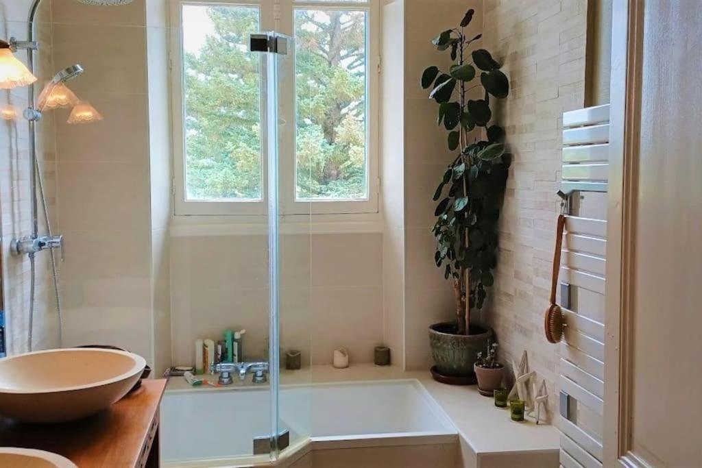 a bathroom with a tub and a sink and a window at Maison de maître parc privé proche Crest et Drôme. in Crest