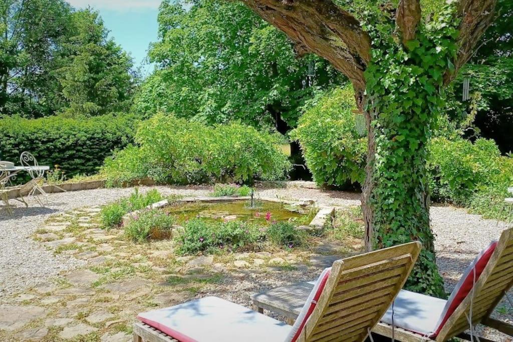 a garden with two chairs and a tree at Maison de maître parc privé proche Crest et Drôme. in Crest