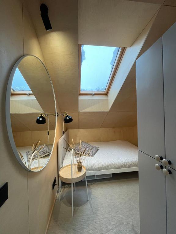 a small room with a bed and a mirror at Amber bay Juodkrantė in Juodkrantė