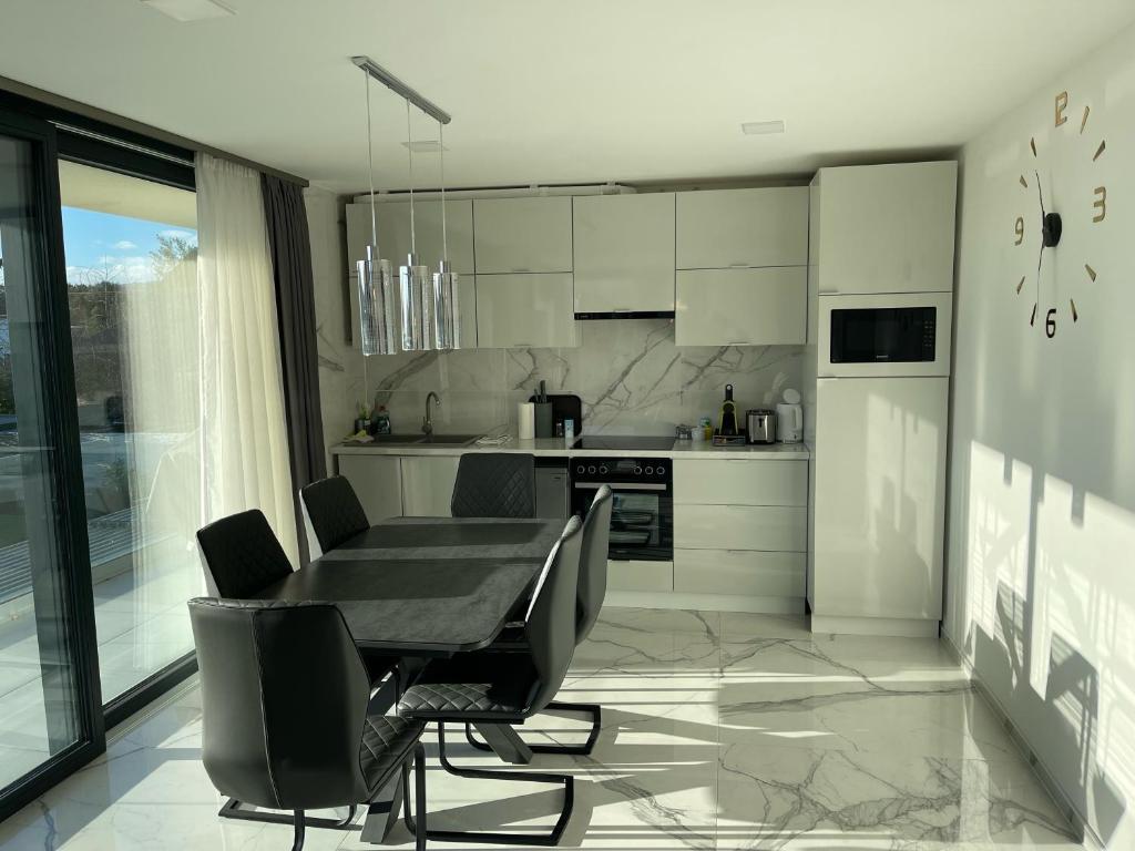 kuchnia ze stołem i krzesłami w obiekcie Luxury Apartments in Balatonalmádi, Almádi Lux Apartman II - Crystal White w mieście Balatonalmádi