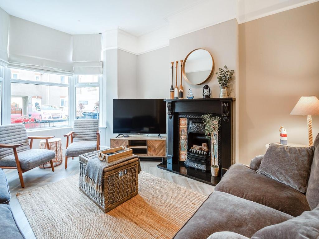 a living room with a fireplace and a tv at Townhouse in Llandudno