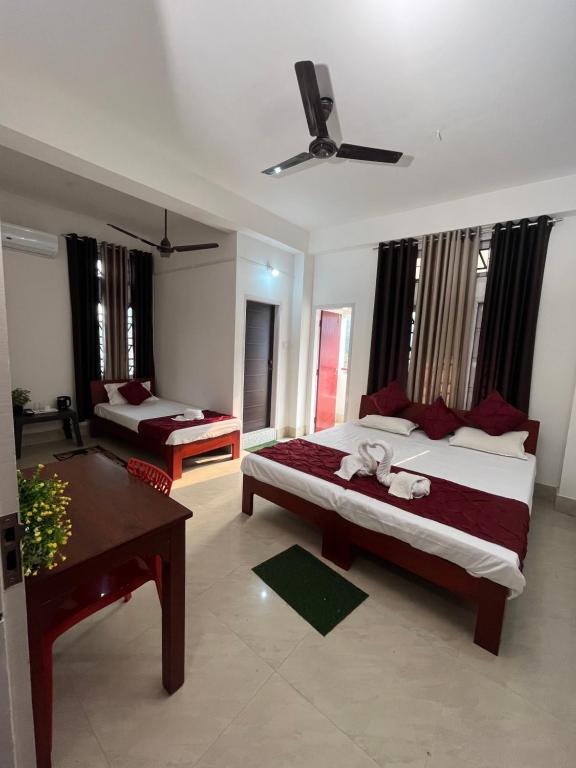 um quarto com duas camas e uma mesa em USC Home Stay-307 em Guwahati