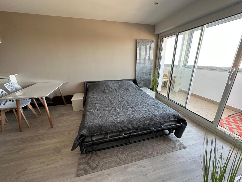 a bedroom with a bed and a desk and a table at Les sables d'or, vue mer, wifi et parking privé in Saint-Hilaire-de-Riez