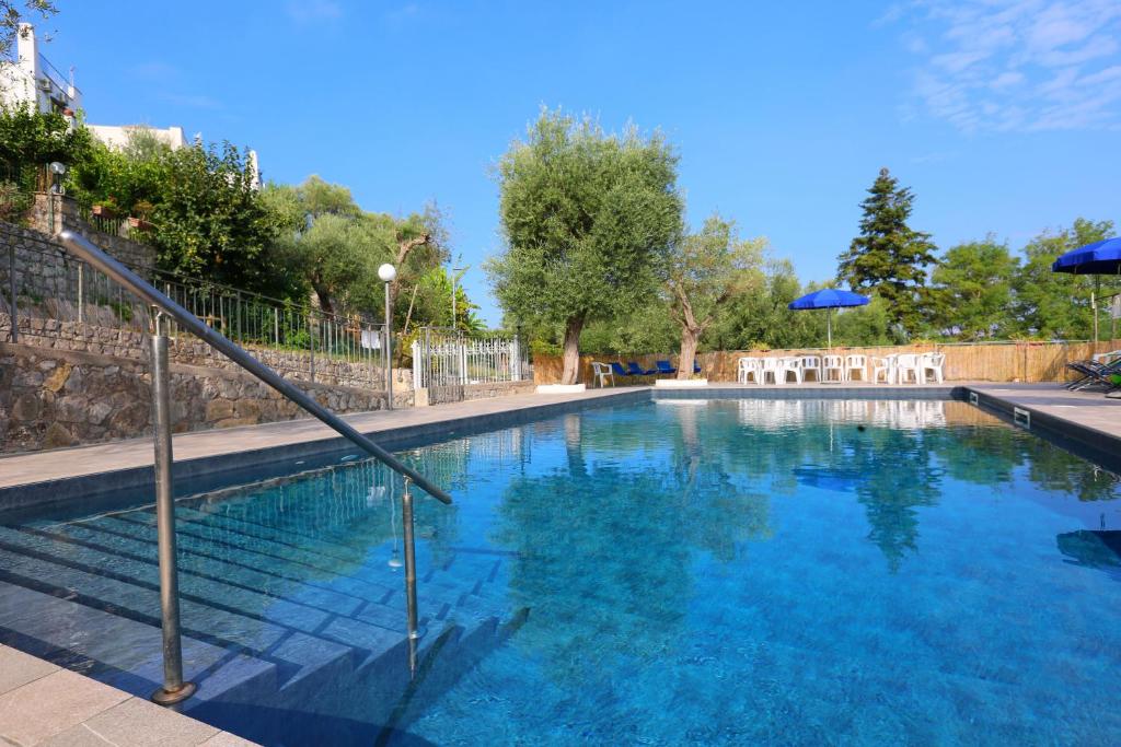 a large swimming pool with blue water and umbrellas at AMORE RENTALS - Villa Tittina in Sorrento