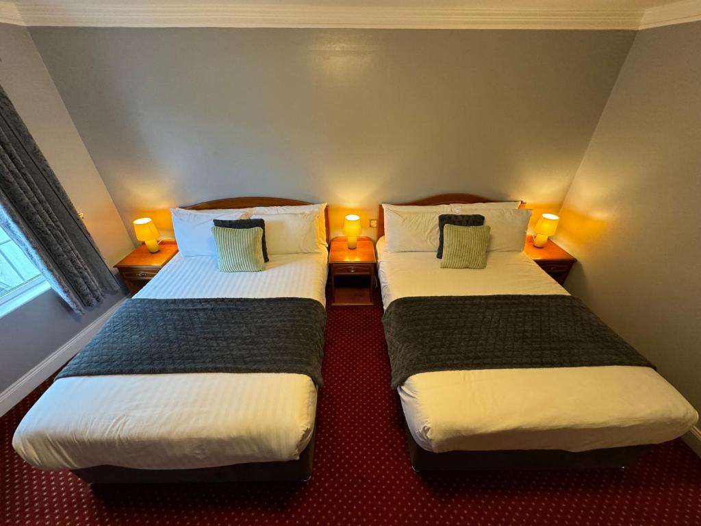 Postel nebo postele na pokoji v ubytování The Killarney Grand