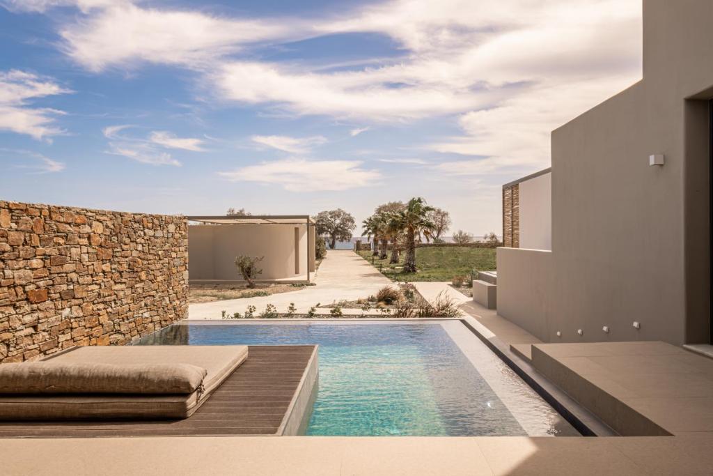 a swimming pool in the backyard of a house at Yenesis Seaside Retreat - Adults only in Tinos