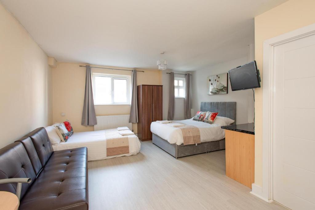 une chambre d'hôtel avec deux lits et un canapé dans l'établissement Saffron Studios, à Orpington